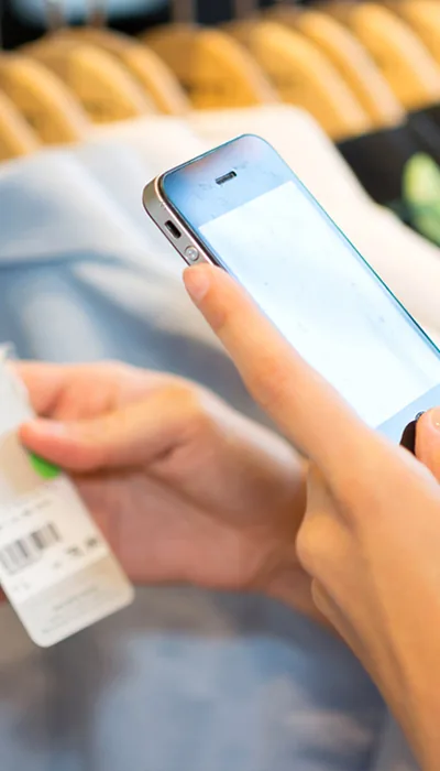 A customer checking a garment’s label on her phone, in store